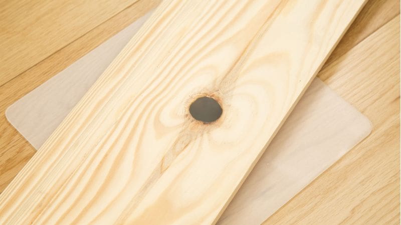 Knot on piece of wood filled with Knottec wood repair compound and sanded to achieve a smooth finish