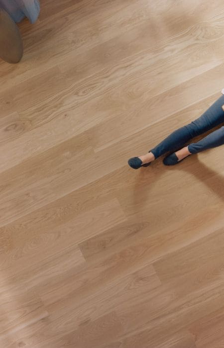 Young woman is sitting on a floor and reading a book