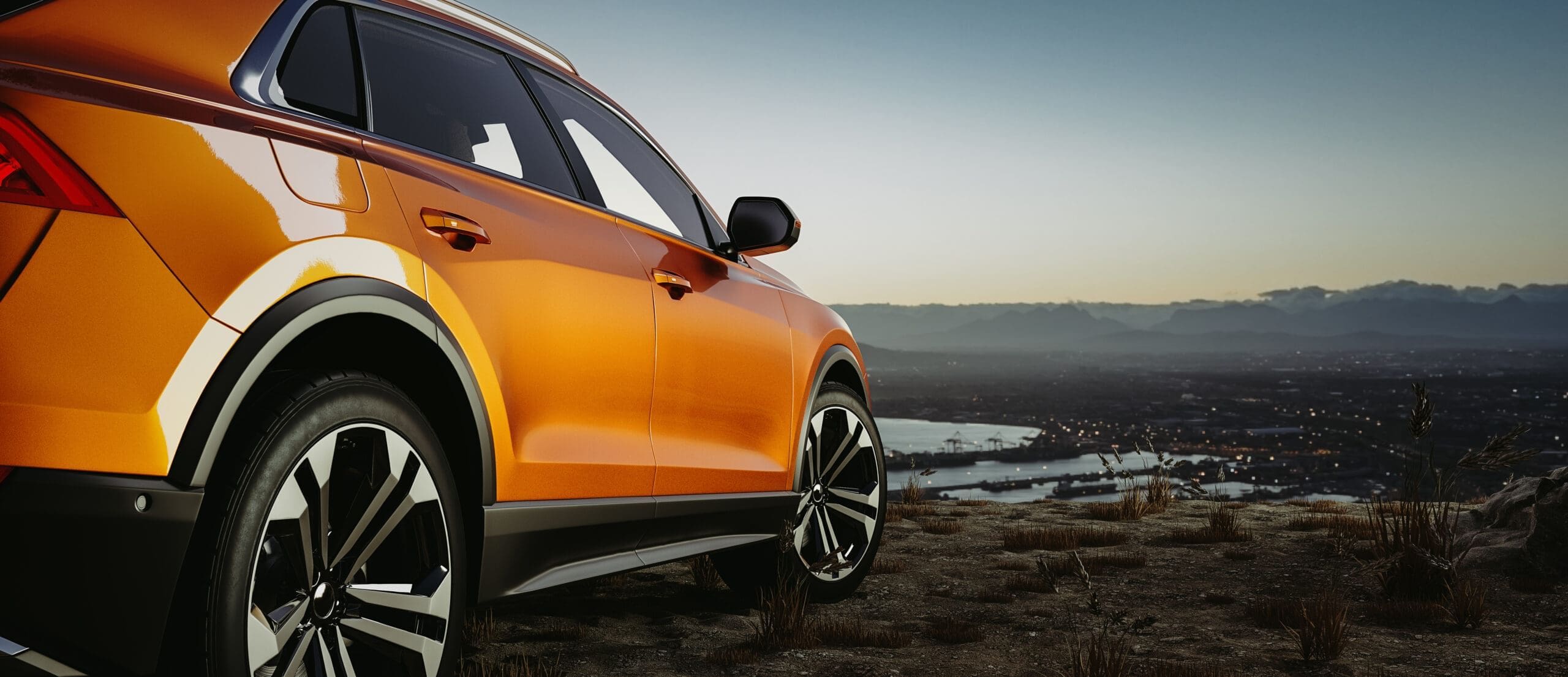 Side of a car with a scenic background as the sun sets