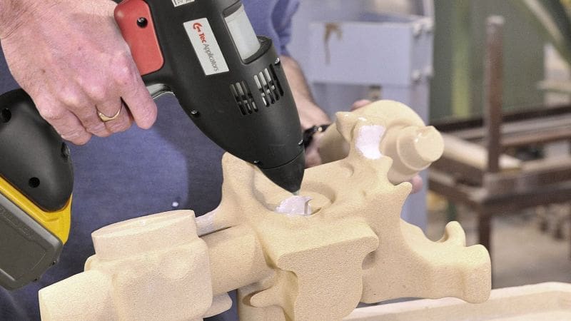 Hot melt adhesive being added to a large section of sand core