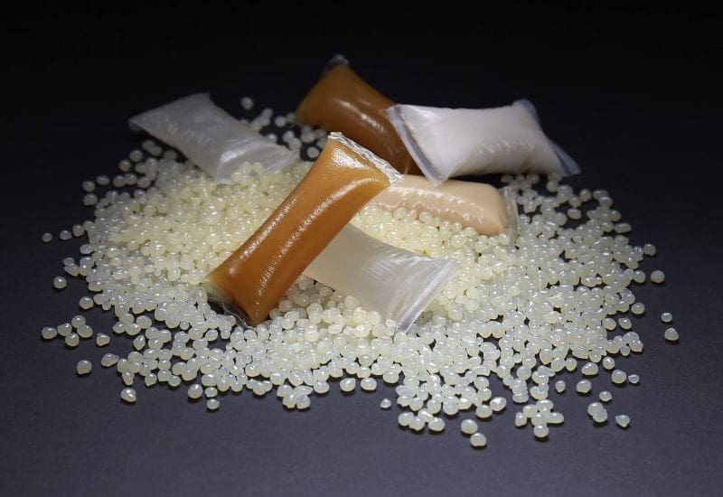 Hot melt bulk adhesives on a black table with black background