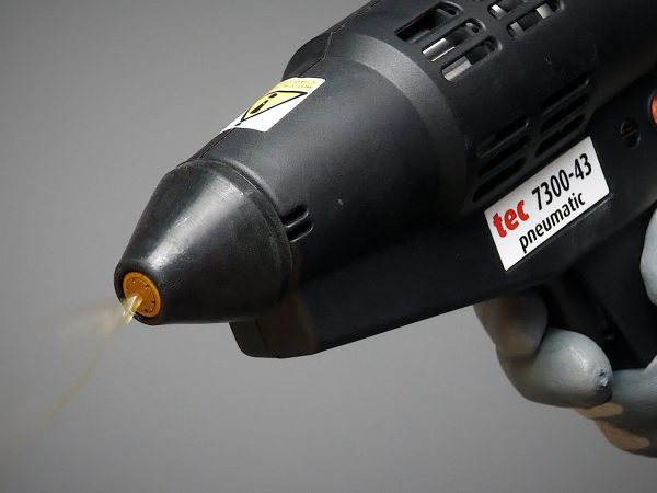 How does the spraytec system work compared to regular spray adhesives?