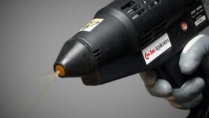 Front of Tec 7300 spray glue gun. Adhesive is being dispensed out of the front in a swirl pattern